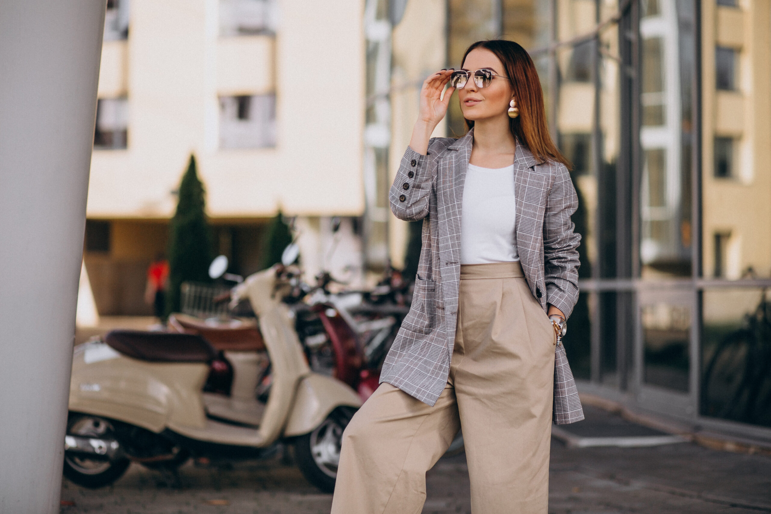 young woman in suit standing by the scooter